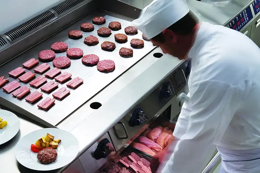 Commercial induction griddle heating up in a busy kitchen