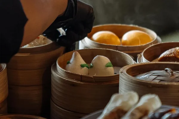 Commercial dim sum steamer with stainless steel compartments for high-volume cooking.